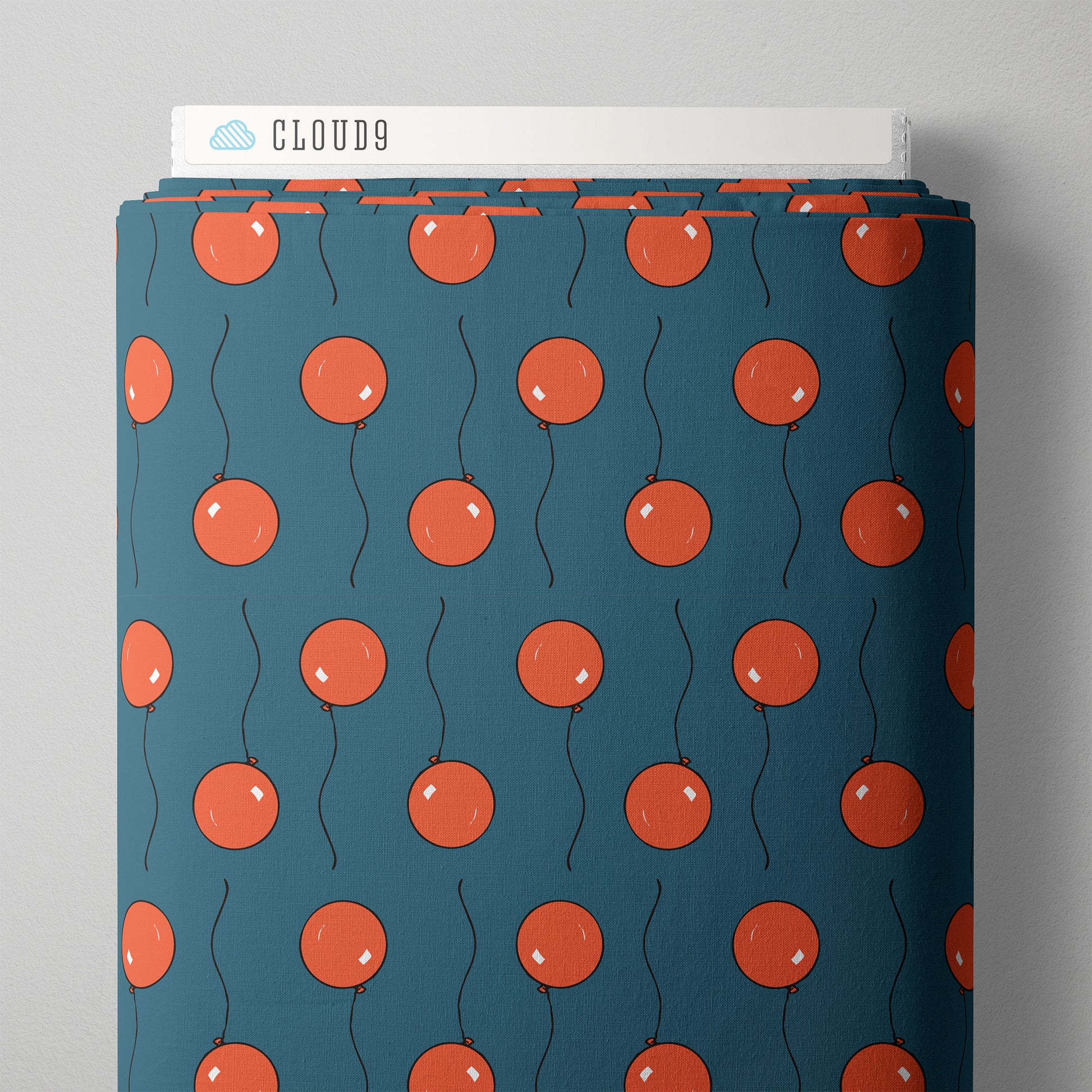 A bolt of fabric with red cartoon ballons against a blue background 