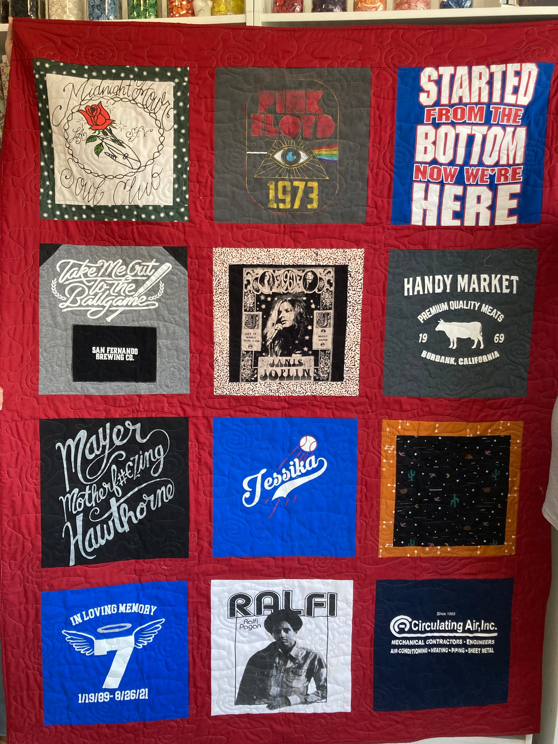 Quilt with various printed t-shirt patches on a red background
