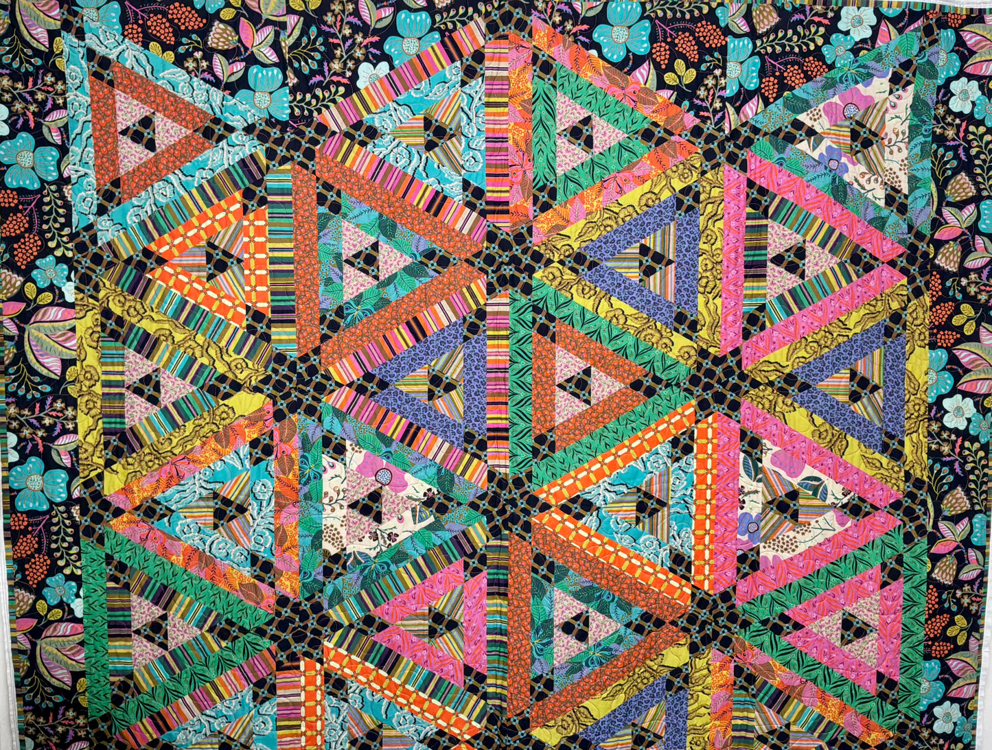 Colorful geometric quilt with triangles on a dark background