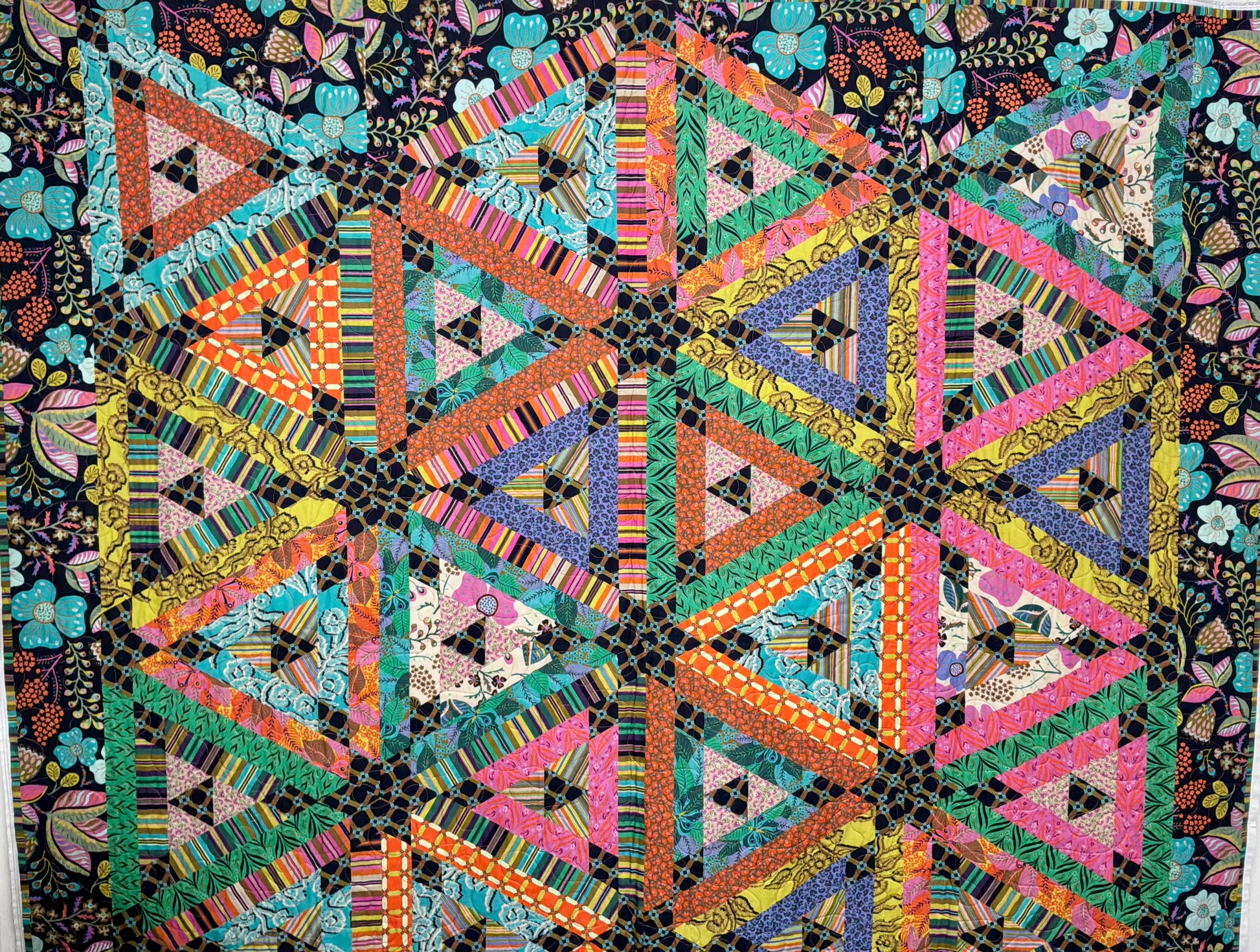 Colorful geometric quilt with triangles on a dark background