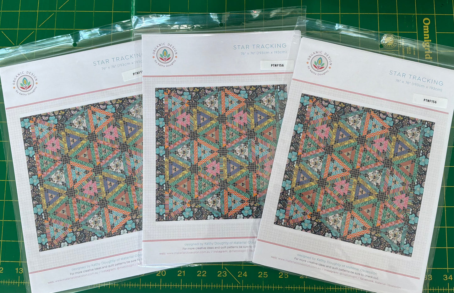 Three pattern sheets with geometric designs on a green cutting mat.