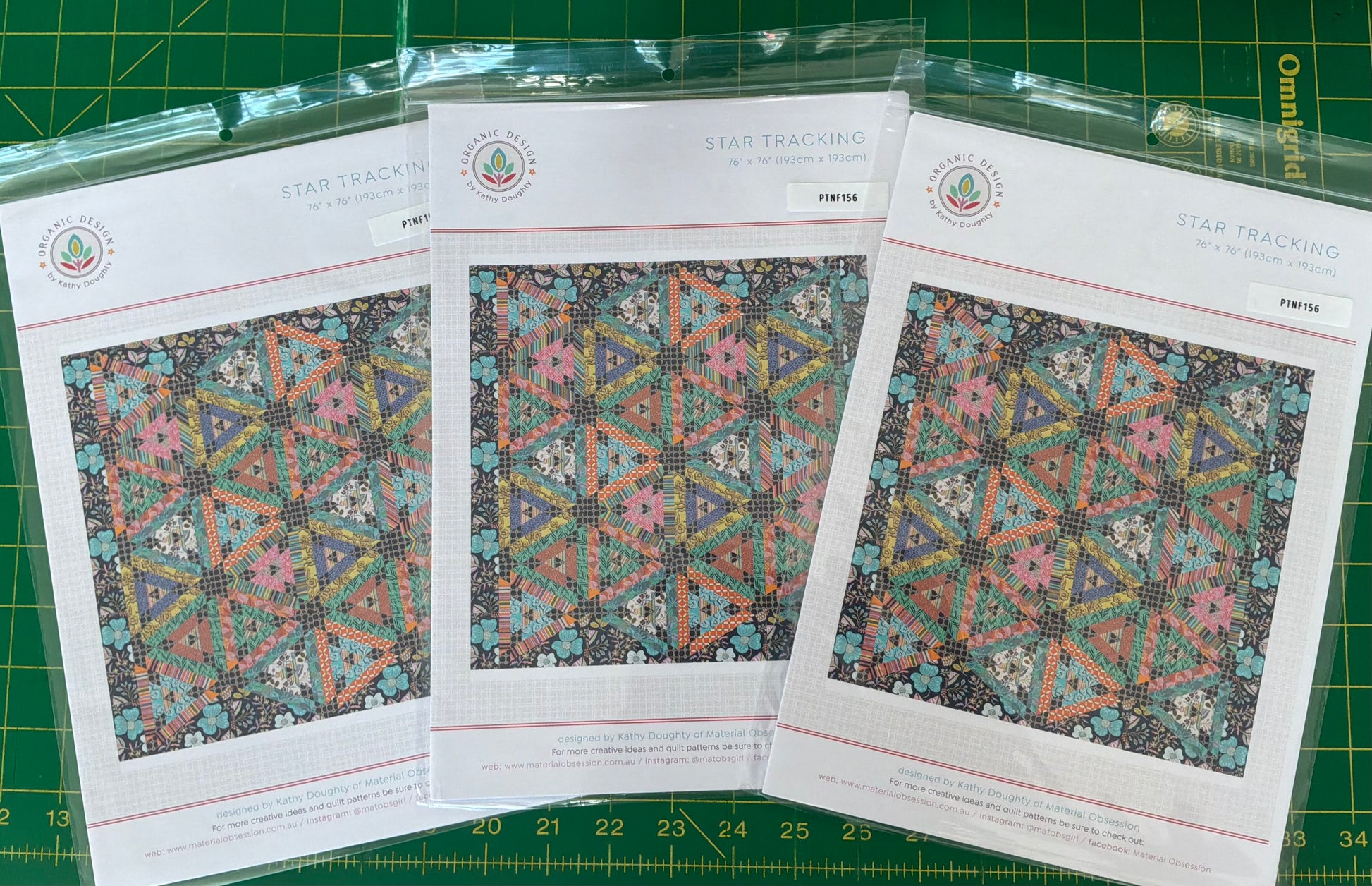 Three pattern sheets with geometric designs on a green cutting mat.
