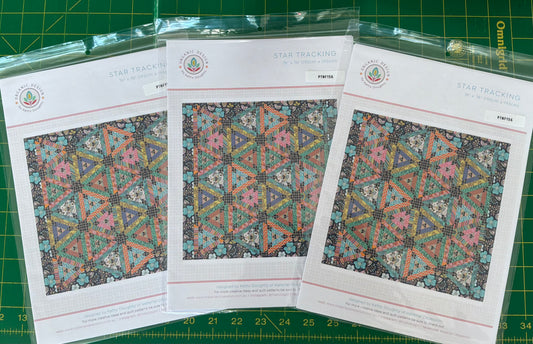 Three pattern sheets with geometric designs on a green cutting mat.