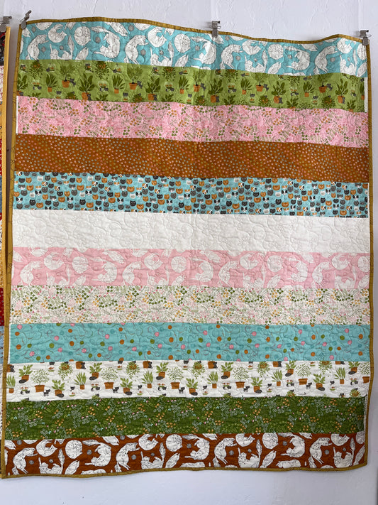 Striped quilt with various patterns and colors on a white background