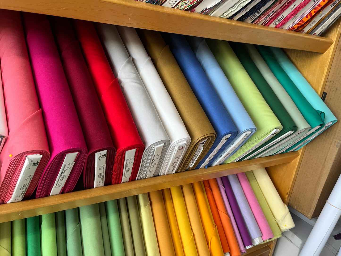 Colorful binders arranged on wooden shelves