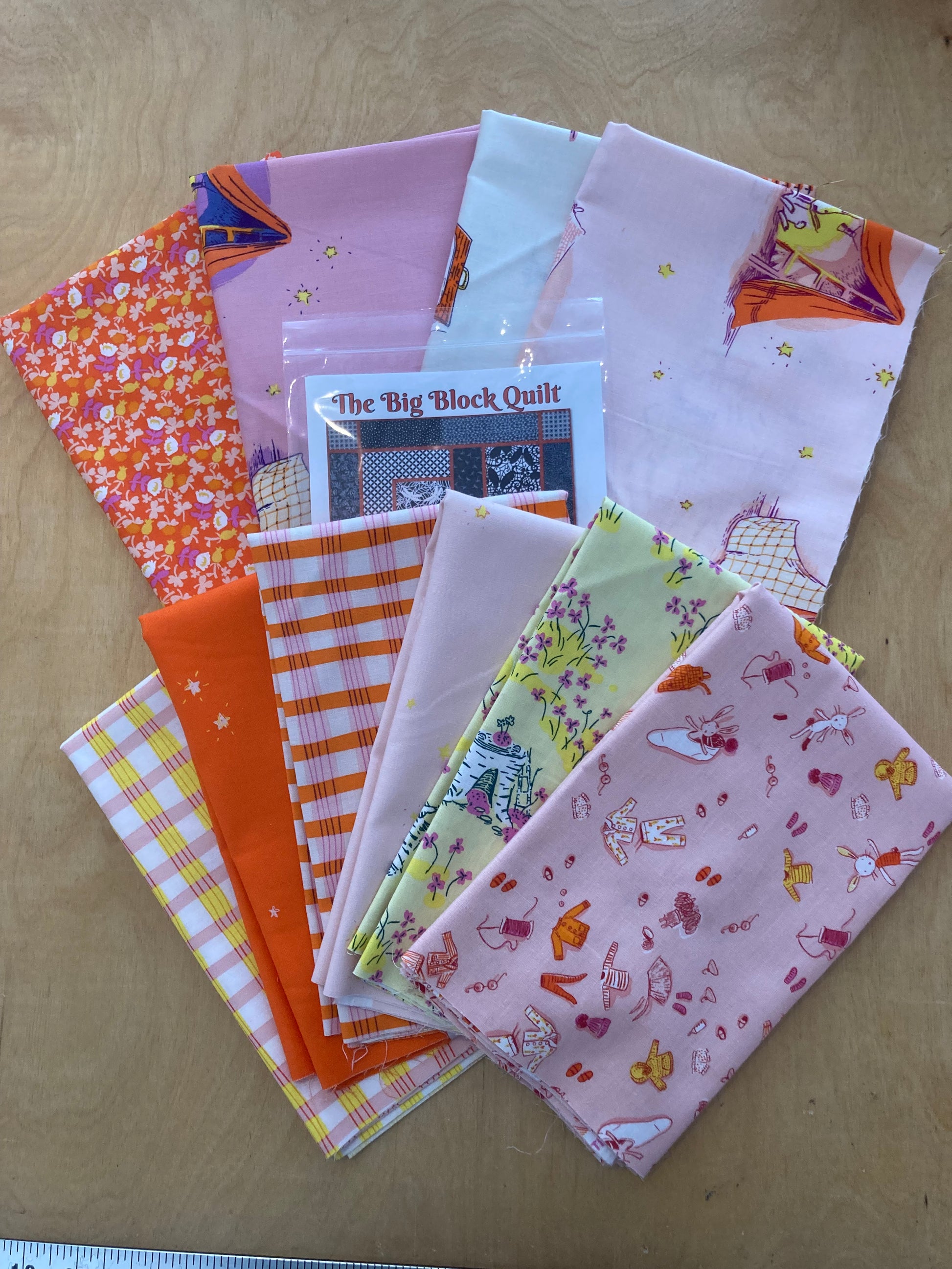 precut fabric in pink, yellow and orange with a quilt pattern