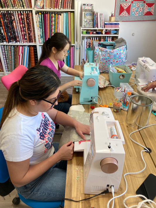 2 people sewing at a table
