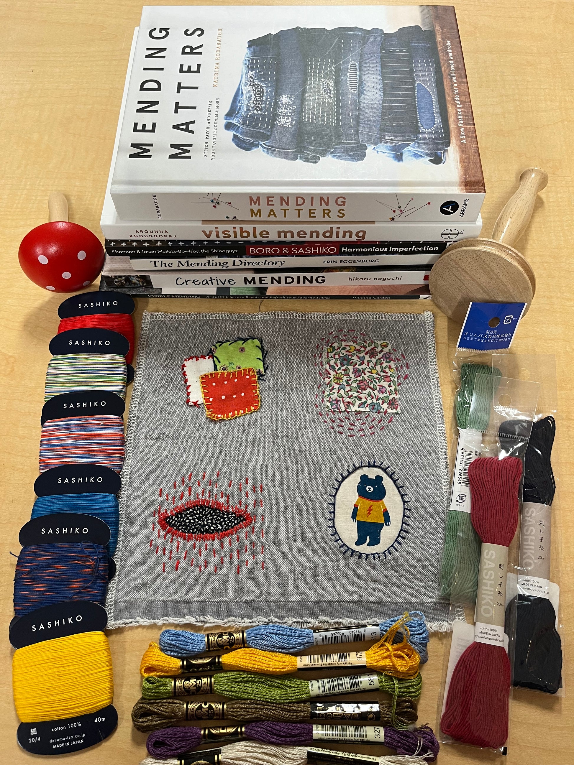 Books, sampler, darning tools, and floss.