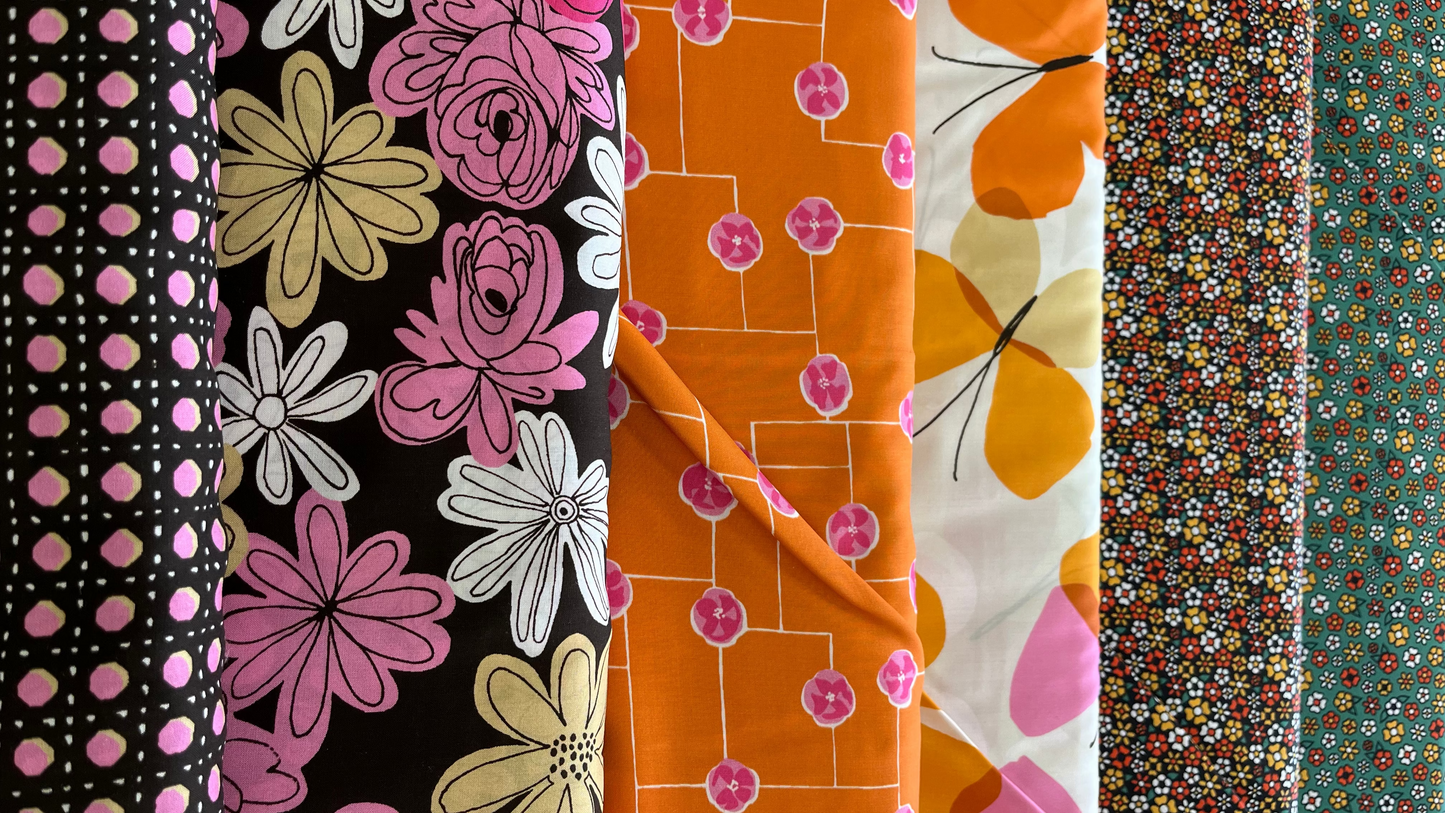Collection of colorful fabric swatches with floral and polka dot patterns.