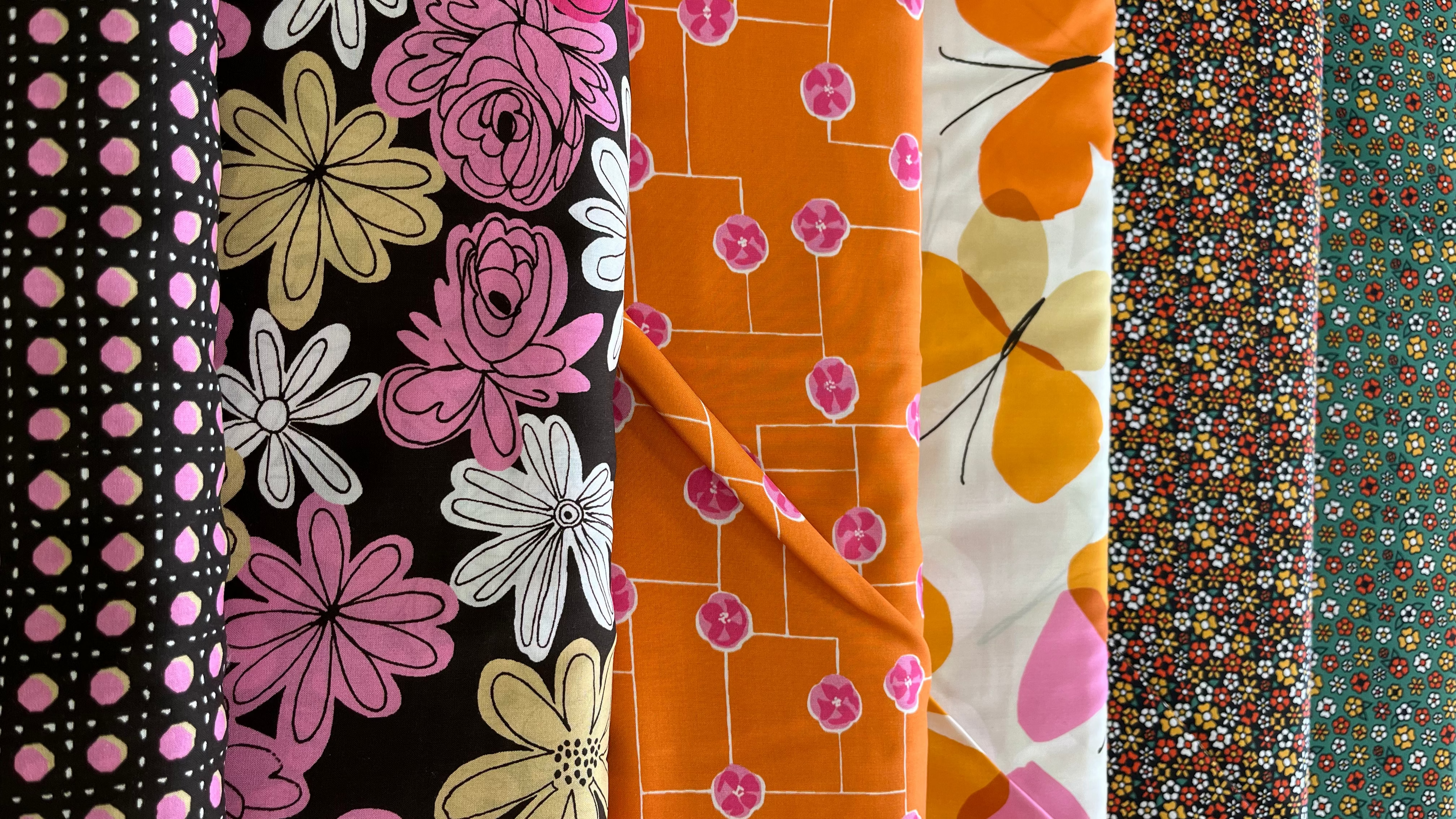 Collection of colorful fabric swatches with floral and polka dot patterns.