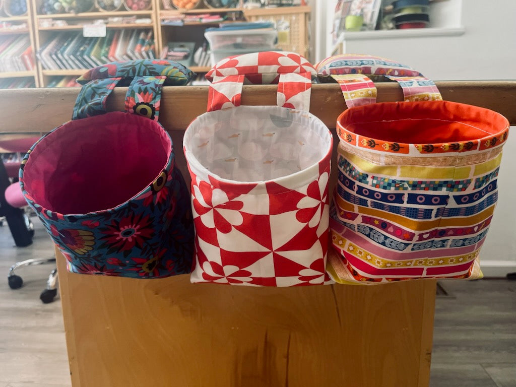 colorful fabric bins hanging from a table