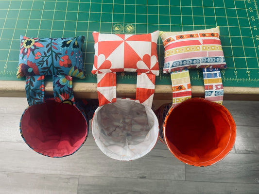 overhead view of colorful fabric bins hanging from a table