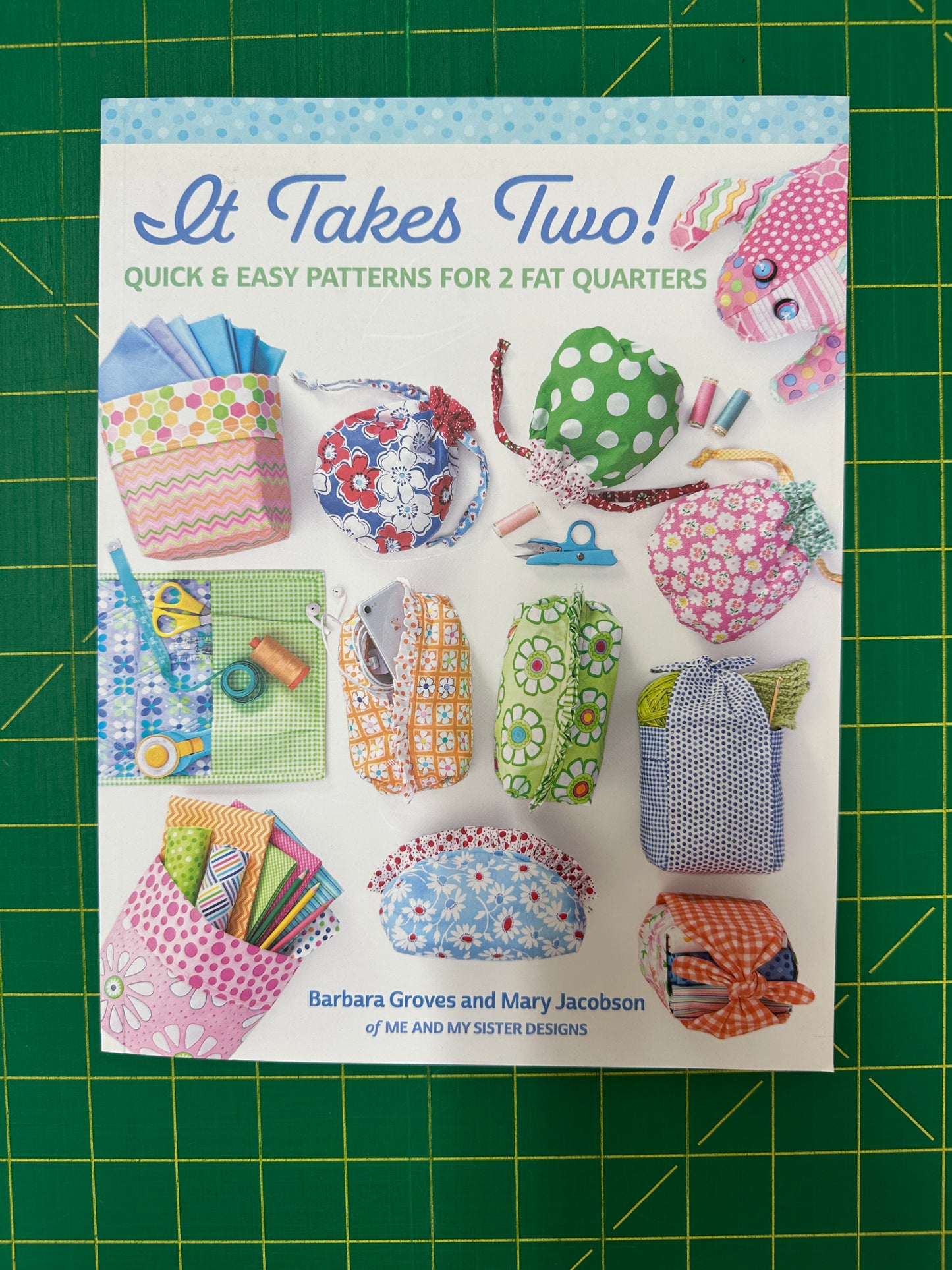 Book titled "It Takes Two!" on a green cutting mat 