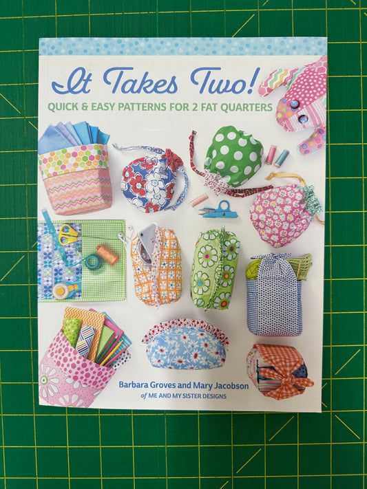Book titled "It Takes Two!" on a green cutting mat 