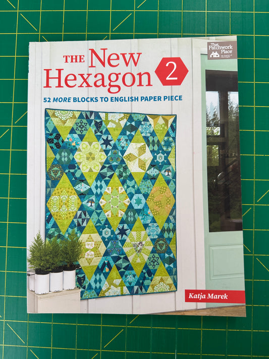 Book titled "The New Hexagon 2" on a green cutting mat 