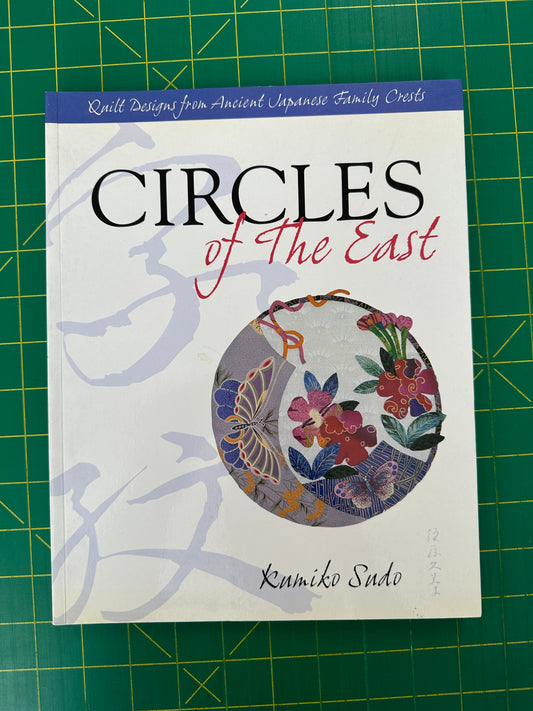 Book titled Circles of the East on a green cutting mat 