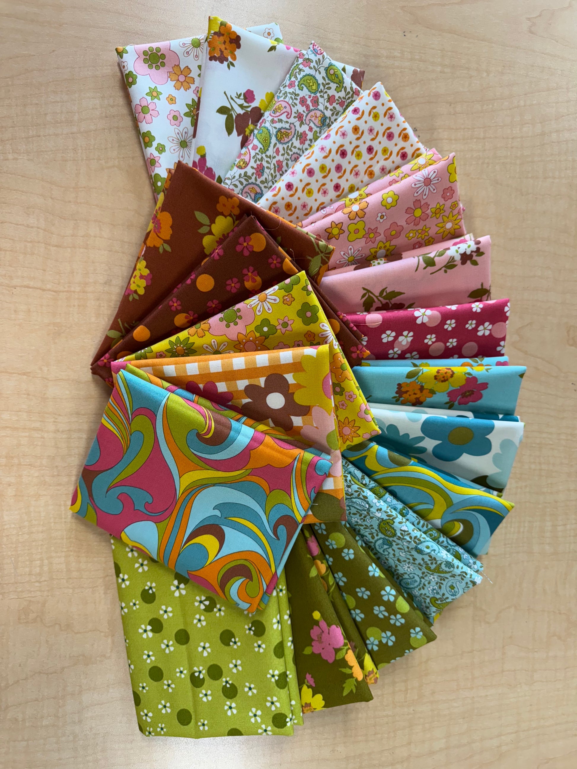 Collection of colorful fabric swatches arranged on a wooden surface