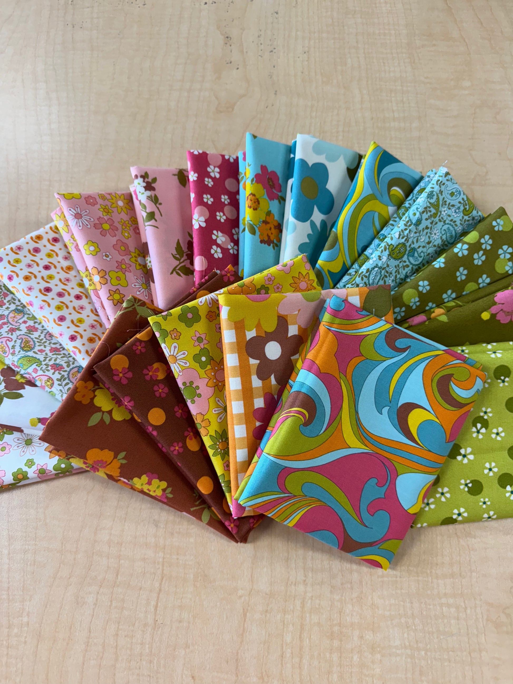 Collection of colorful fabric swatches arranged on a wooden surface