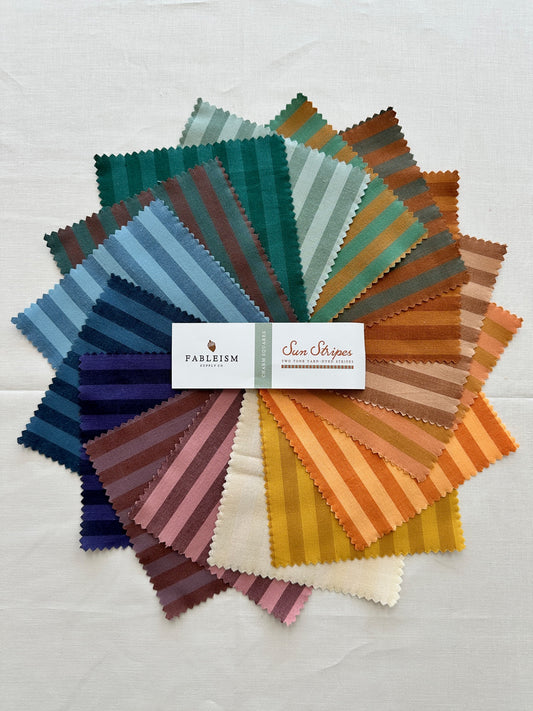 Fableism Sun Stripe Fabric arranged in a colorful splay of squares in various striped patterns 