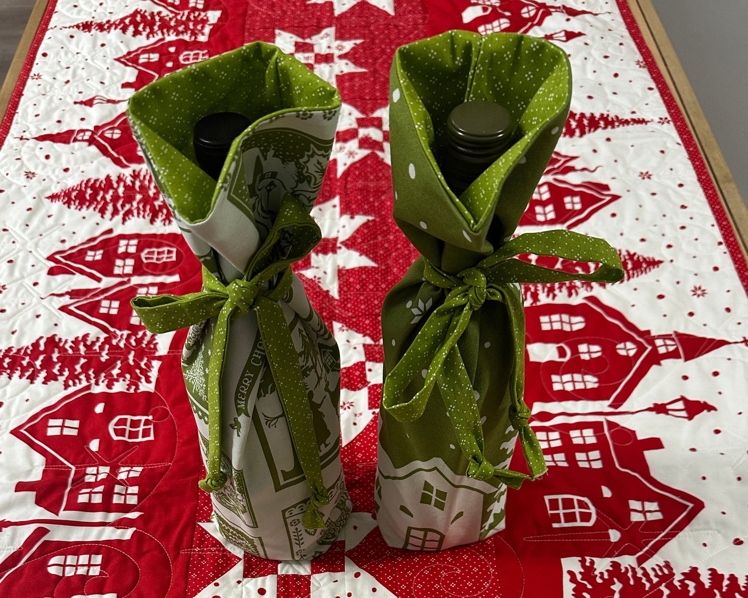 Green fabric windmill on a red and white patterned background with houses and trees.