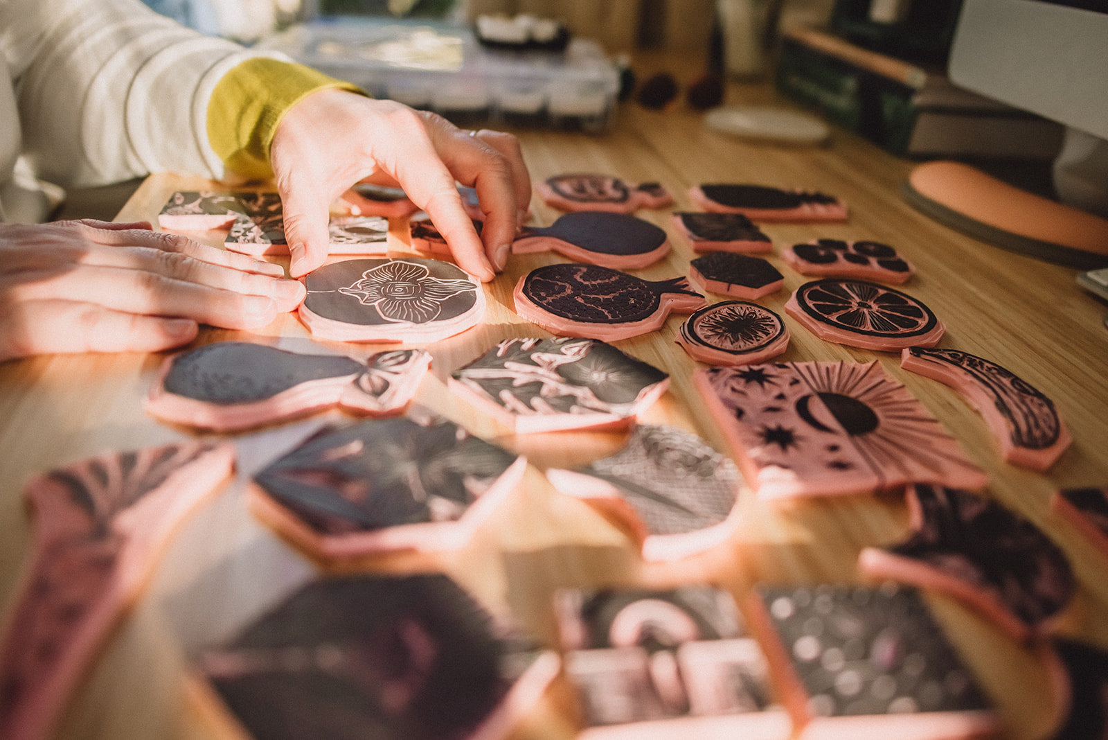 Person arranging decorative items on a wooden surface with a blurred background