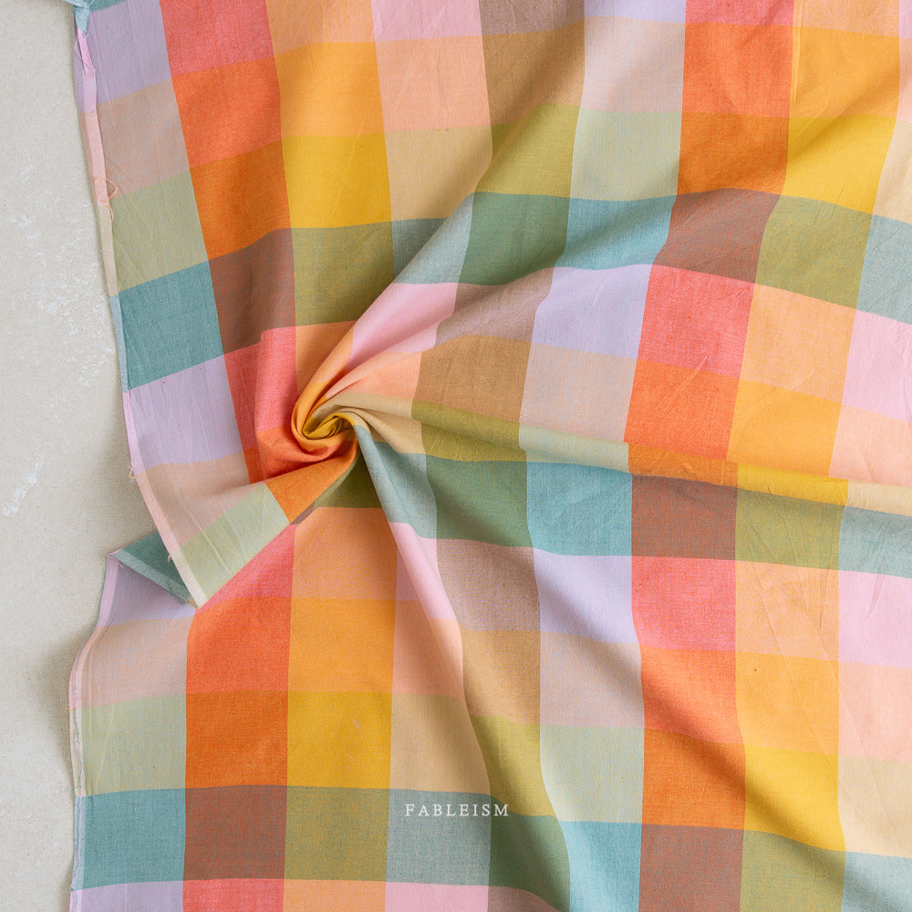 Colorful checkered fabric with 'Fableism' branding on a light background