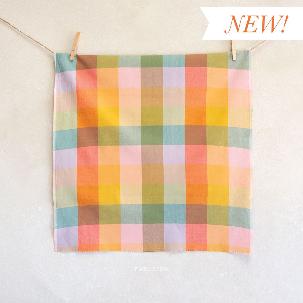 Colorful checkered fabric with 'NEW!' text on a white background