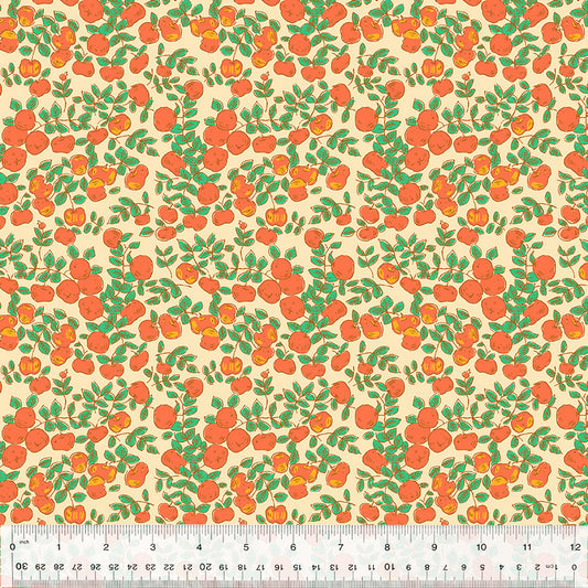 orange apples against a peach background with green leaves