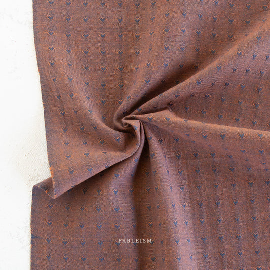 Brown textured fabric with small blue hearts