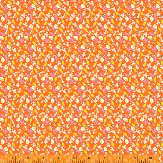 A calico fabric with small white flowers  with orange, pink and yellow accents, against an orange background