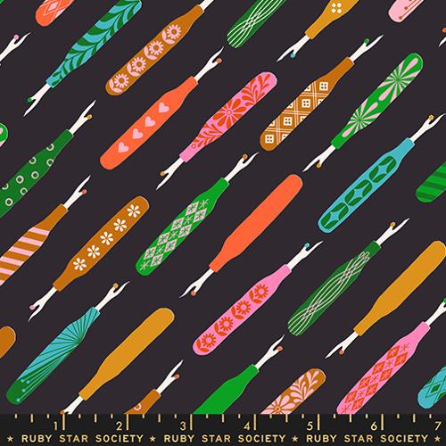 Colorful pattern of fabric swatches seam rippers with a ruler at the bottom on a black background, featuring designs by Ruby Star Society.