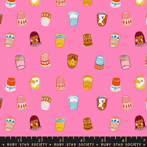 Patterned fabric with cartoon-style thimbles on a pink background, featuring a ruler at the bottom.