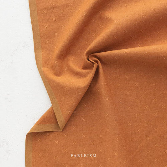 Dark orange fabric with subtle texture against a white background