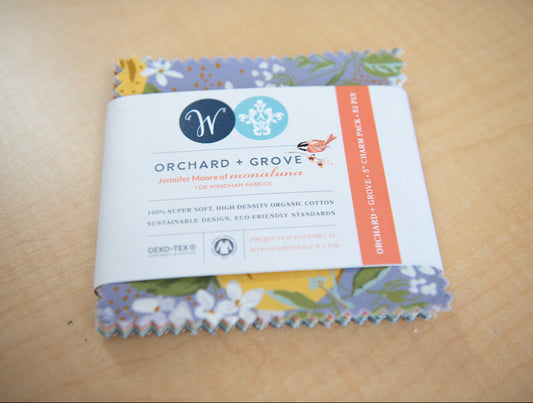 Pack of fabric squares with a visible brand label on a wooden surface