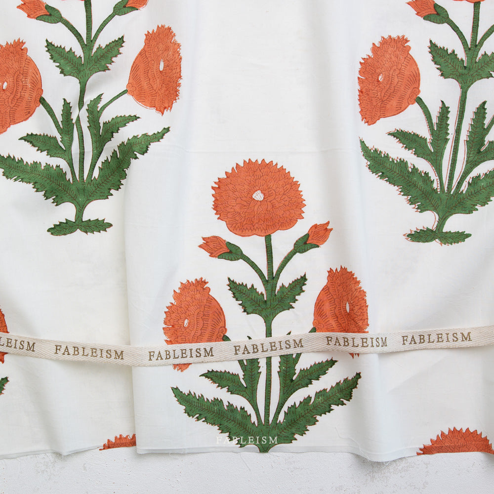 Floral patterned fabric with green leaves and orange flowers, featuring the brand 'Fableism'.