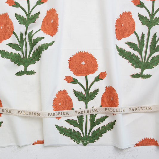 Floral patterned fabric with green leaves and orange flowers, featuring the brand 'Fableism'.