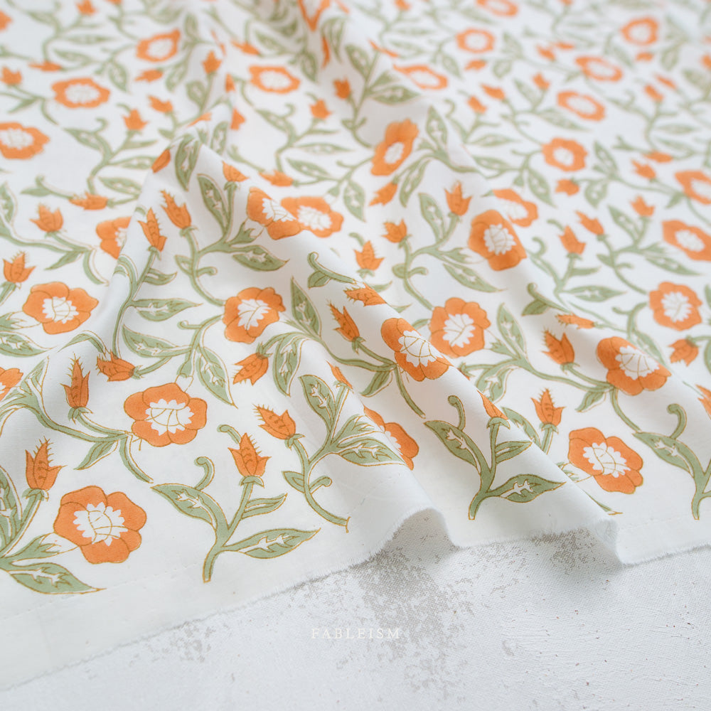 Floral fabric with orange and green flowers on a white background