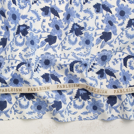 Blue floral pattern on white fabric with 'Fableism' label.