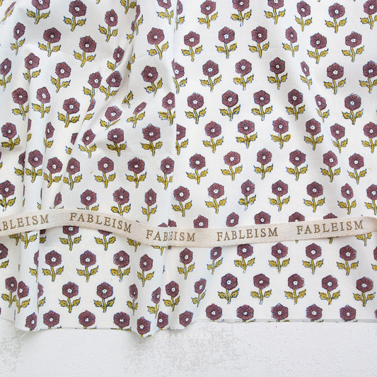 Floral patterned fabric with 'Fableism' branding on a white background