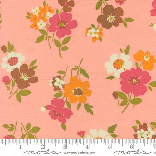 Pink, white, orange, and brown flowers with green stems on a pink colored background with Moda ruler at the bottom
