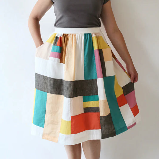 Colorful striped skirt worn by a person on a plain background