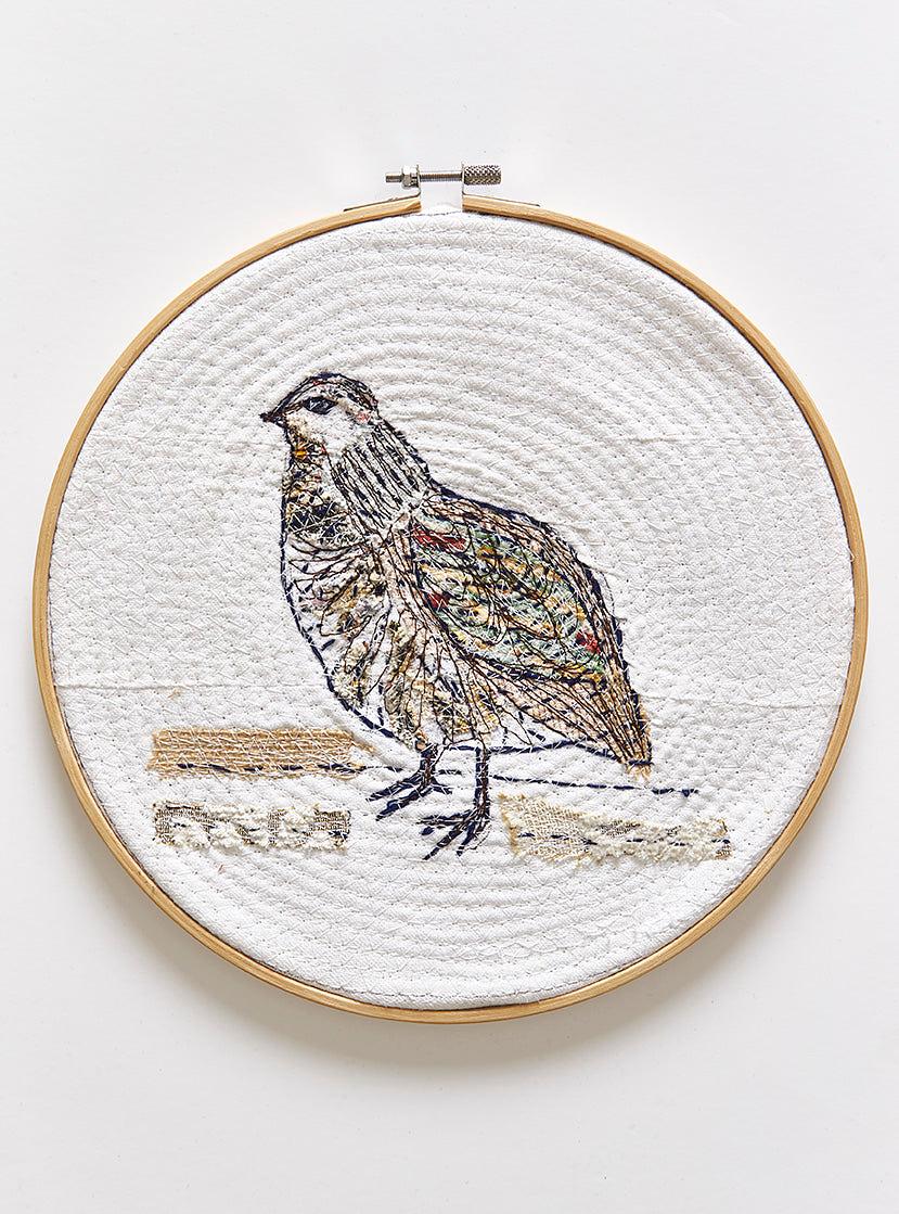 hand stitched bird in embroidery hoop