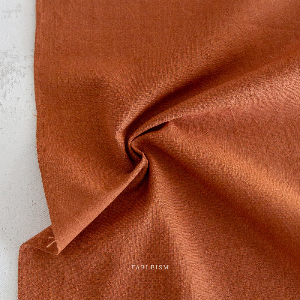 Rust fabric with embroidered X detail