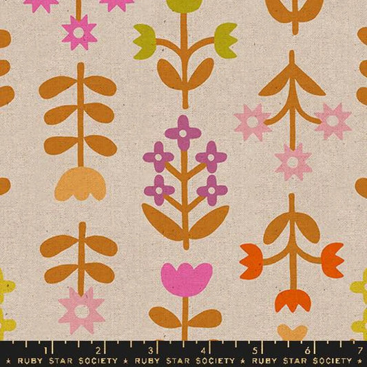 A close up of tan fabric with a brown, green and purple floral print 
