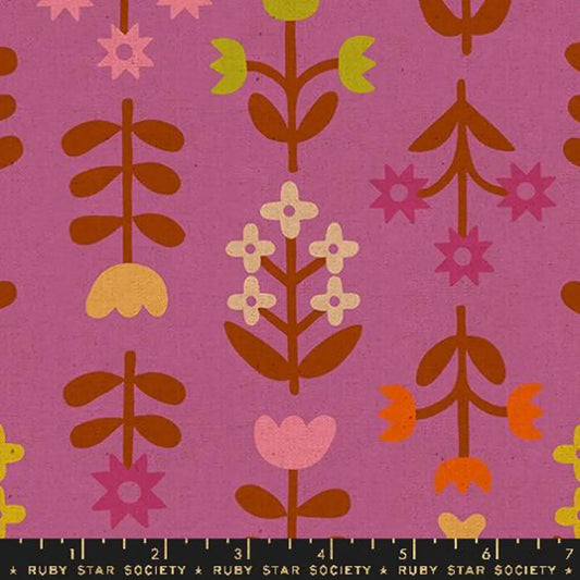 A close up of magenta fabric with a brown, tan and yellow floral print 
