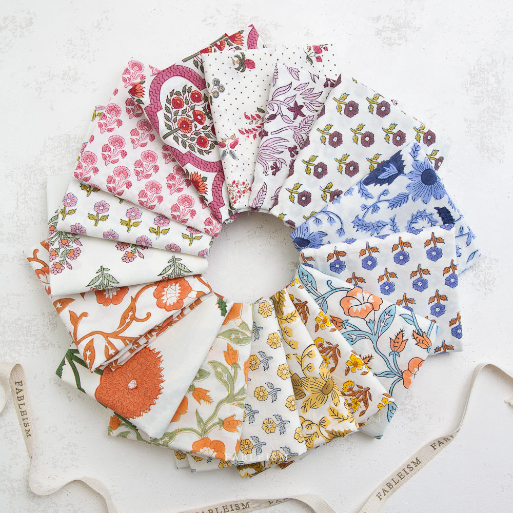 Circular arrangement of fabric swatches with various floral patterns on a textured surface.