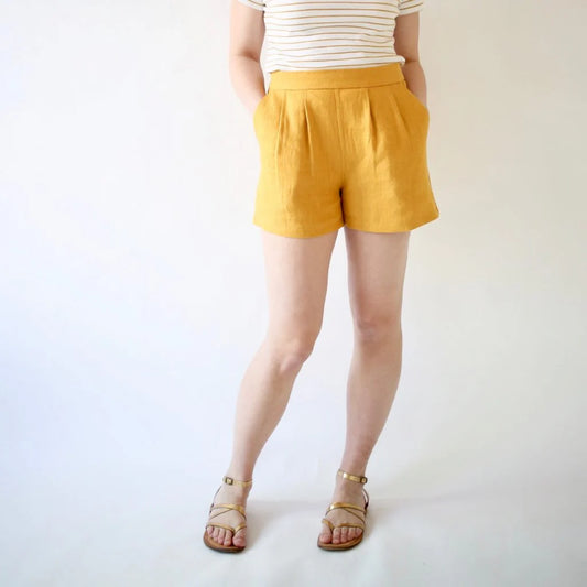 Person wearing mustard yellow shorts on a white background