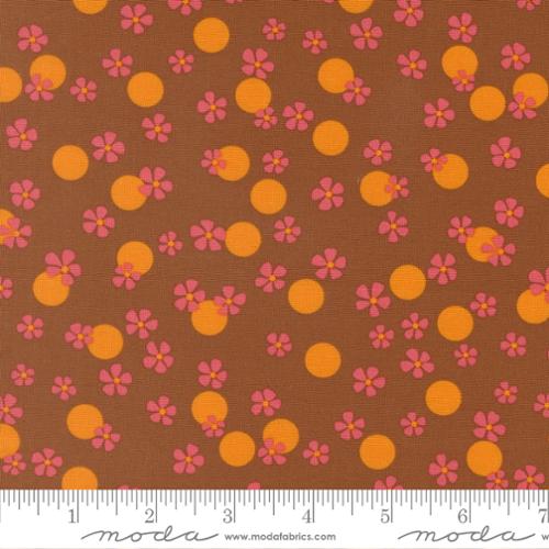 Pink flowers and orange dots on a brown background with the Moda ruler below