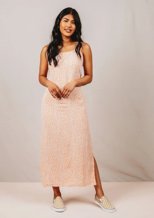 Woman wearing a pink slip dress against a neutral background 