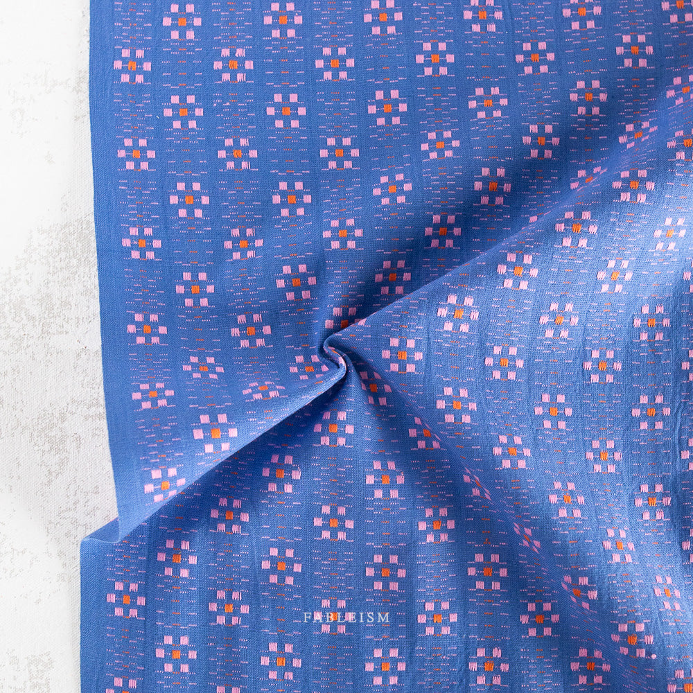 woven flowers in pink and orange on blue